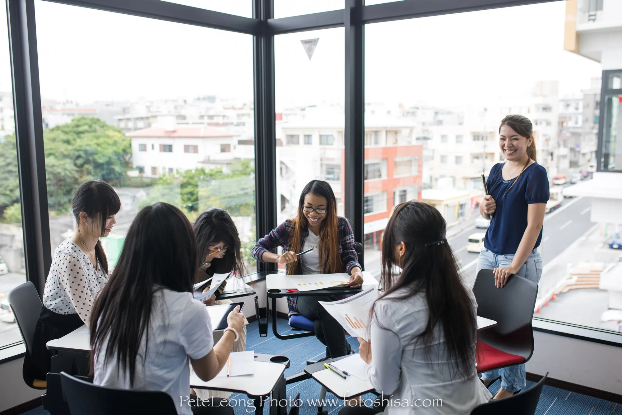 A teacher standing, facing students learning Japanese.